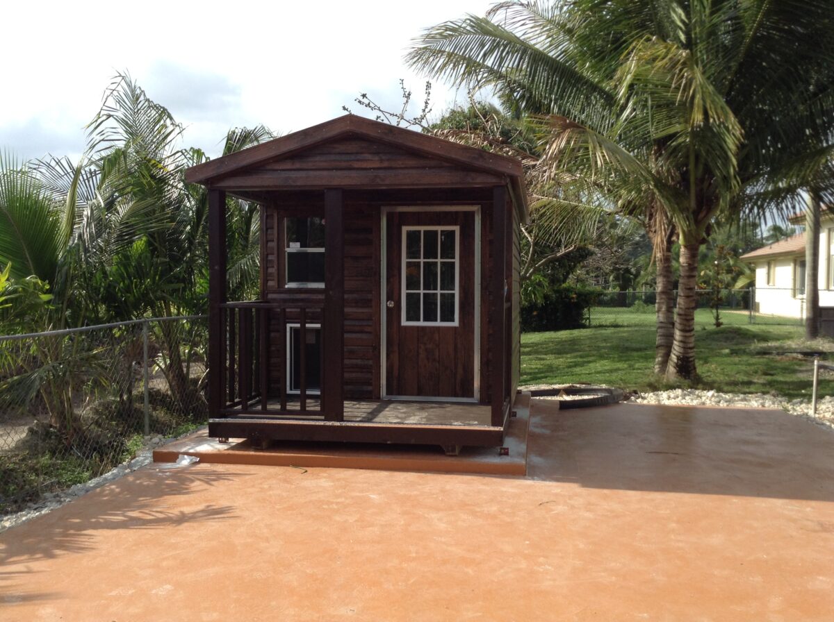 A small wooden cabin sitting in the middle of a yard.